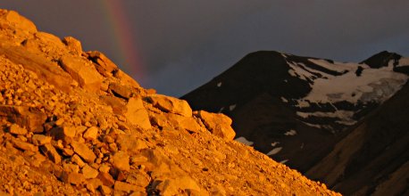 A rainbow forms at dawn