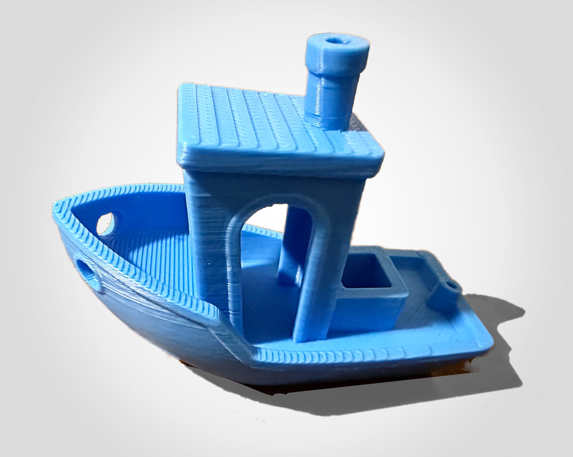 Photo of a blue boat, Benchy, often used as a test print