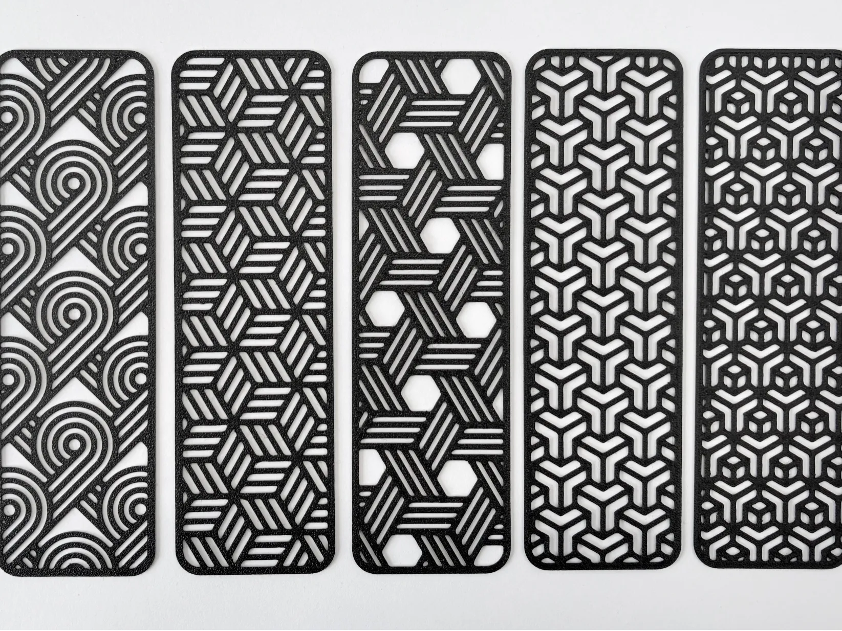 Several geometric line art bookmarks from MakerWorld, shown printed in Matte Charcoal PLA